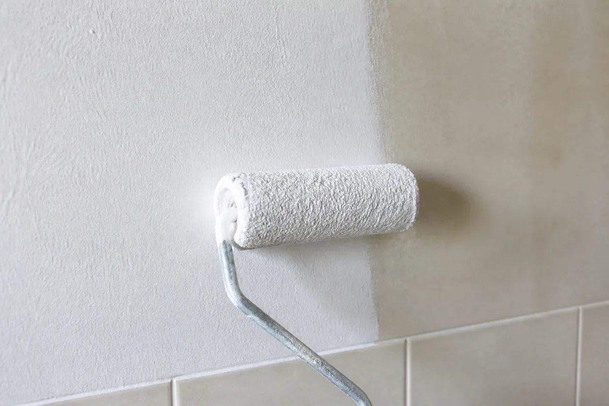 Peinture satinée claire appliquée au rouleau sur le mur d&rsquo;une salle d&rsquo;eau lumineuse